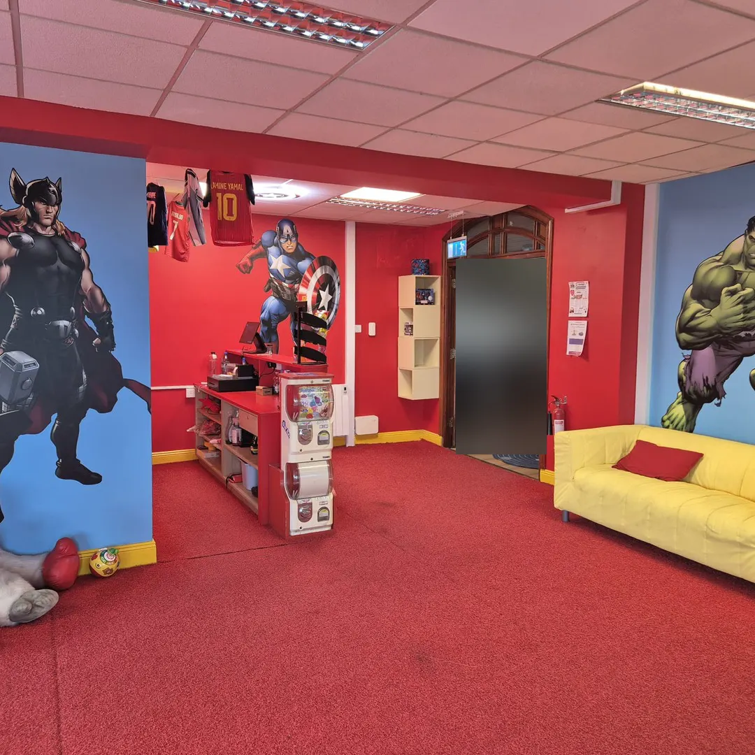 A red and blue room with Thor, Captain America and Hulk wall murals and a yellow sofa.